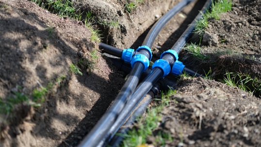 Installed PVC water pipes in trench at summer.