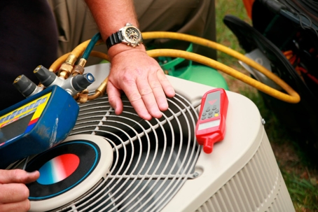 Hand and tools on Outdoor HVAC