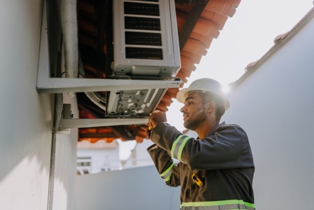 Technician checking air conditioning unit