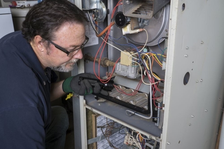 HVAC technician inspecting gas furnace