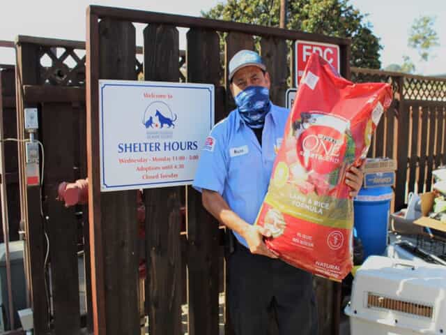 JSP technician holding a bag of dog food 