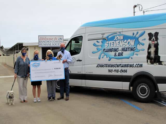 Woman holding $10k check next to John Stevenson Van